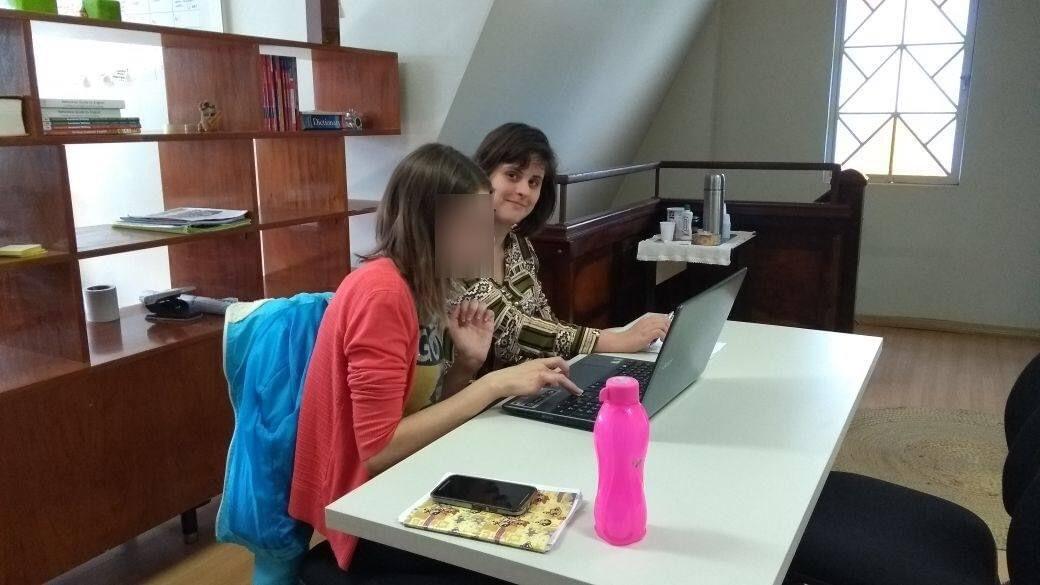 A person sitting at a table with a computer

Description automatically generated